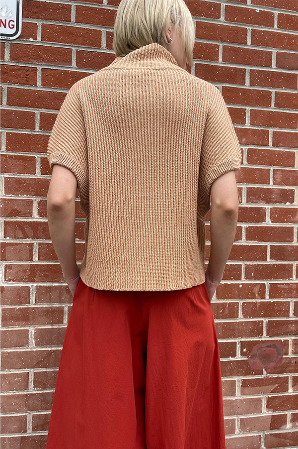 Ribbed knit sleeveless drop should relaxed fit. Cropped high neck sweater. Dusan Cropped high neck sweater.  Ribbed sleeveless sweater Apricot. Linen/cashmere silk blend sweater Dusan. Apricot. Dusan Des Kohan. Des Kohan Los Angeles. Dusan West Hollywood. Des Kohan . Dusan Sleeveless Apricot sweater shown with Terracotta Samurai Dusan Pants.