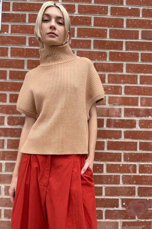 Ribbed knit sleeveless drop should relaxed fit. Cropped high neck sweater. Dusan Cropped high neck sweater.  Ribbed sleeveless sweater Apricot. Linen/cashmere silk blend sweater Dusan. Apricot. Dusan Des Kohan. Des Kohan Los Angeles. Dusan West Hollywood. Des Kohan . Dusan Sleeveless Apricot sweater shown with Terracotta Samurai Dusan Pants.